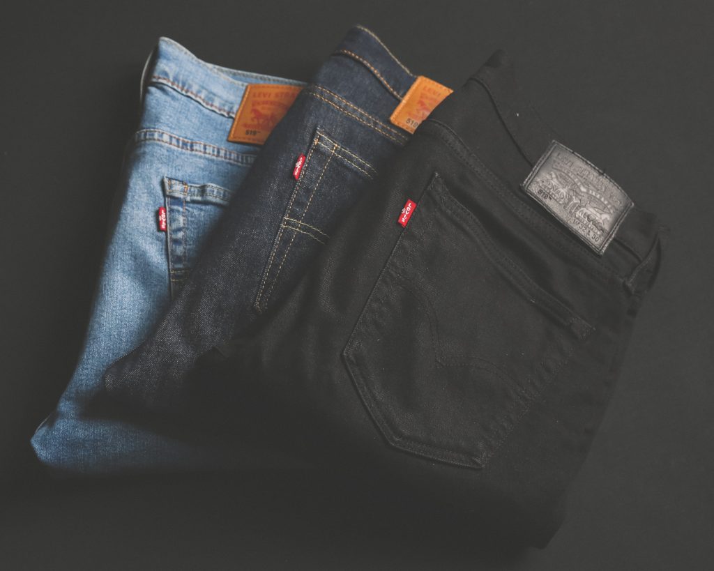 Trois paires de jeans pliées. Coloris bleu clair, bleu foncé et noir.