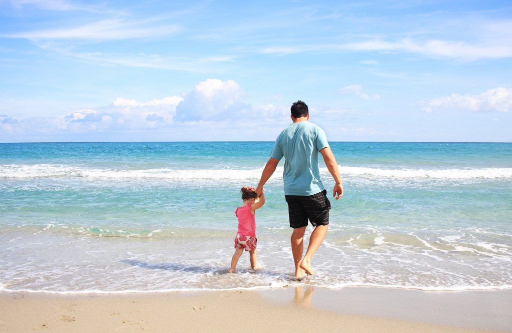 Un papa et sa fille sur une plage